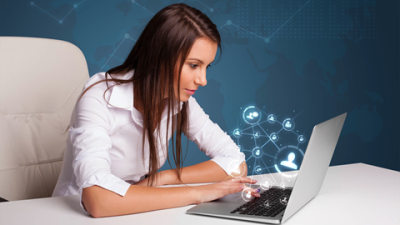 woman staring at computer screen with floating graphics